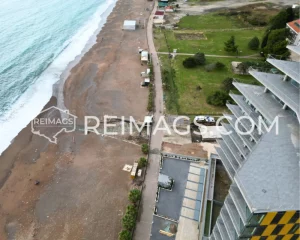 Sea and hotel right by the beach, sandy coastline - Luxury apartments for sale in Becici, Montenegro. Prime real estate with direct access to the Adriatic